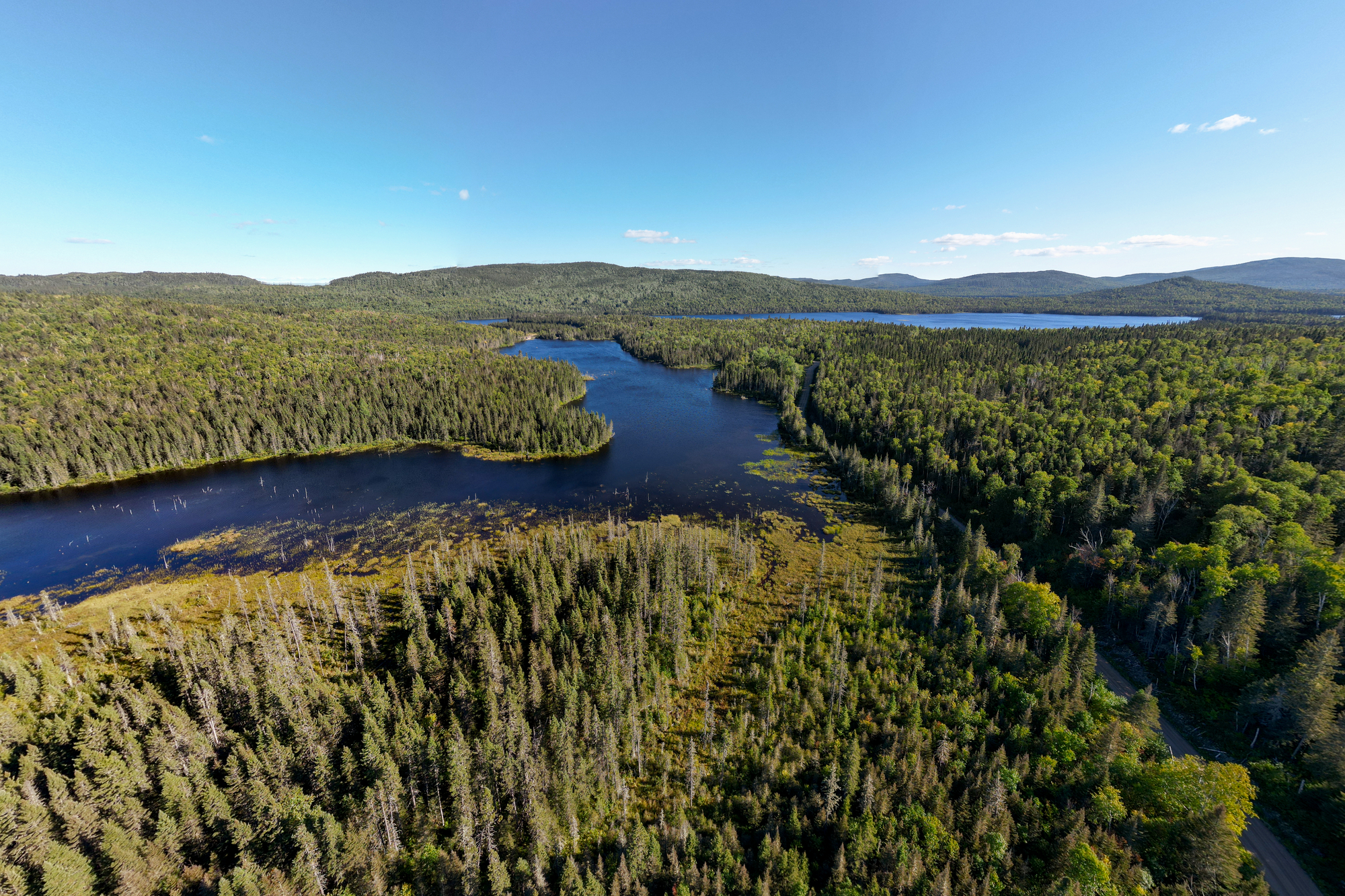 Vue aérienne d'un paysage naturel avec lacs, forêts denses et collines dans la région de Charlevoix, pourvoirie en dehors de la ville
