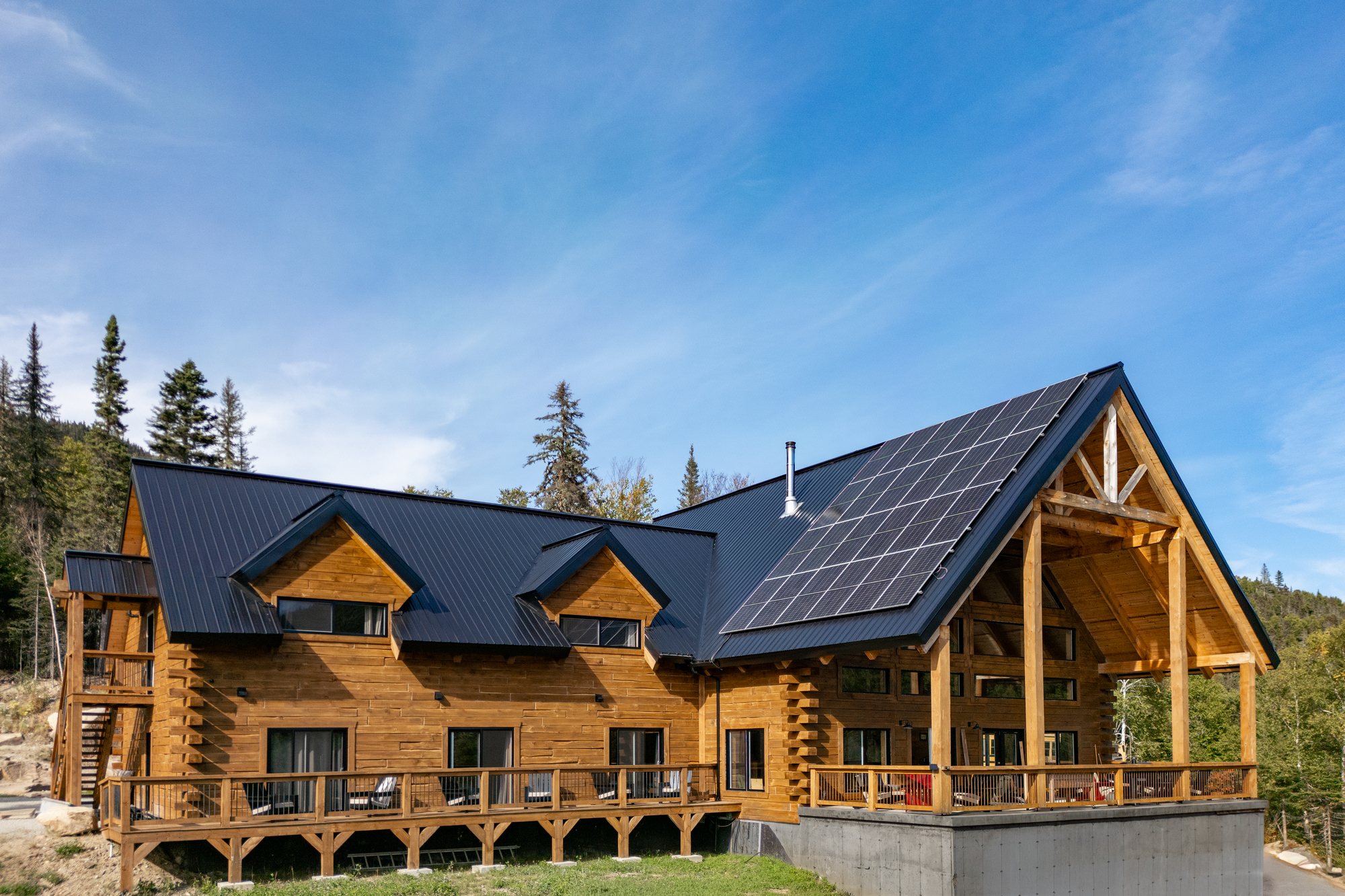 Chalet en bois avec panneaux solaires, situé dans un cadre naturel, près du Domaine du Lac Brouillard en Charlevoix
