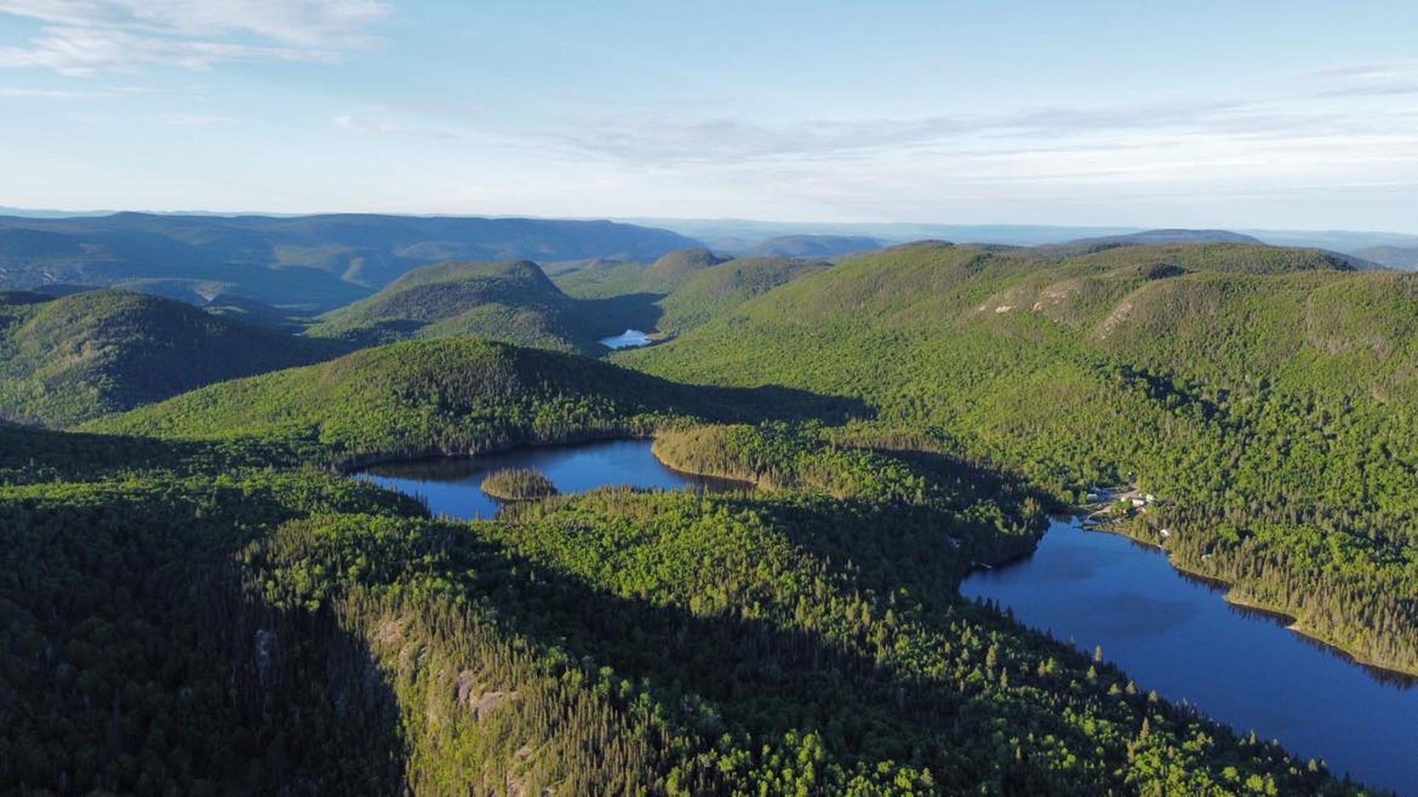 Vue aérienne des vallées verdoyantes et lacs de Charlevoix, cadre naturel du forfait chasse à l’orignal