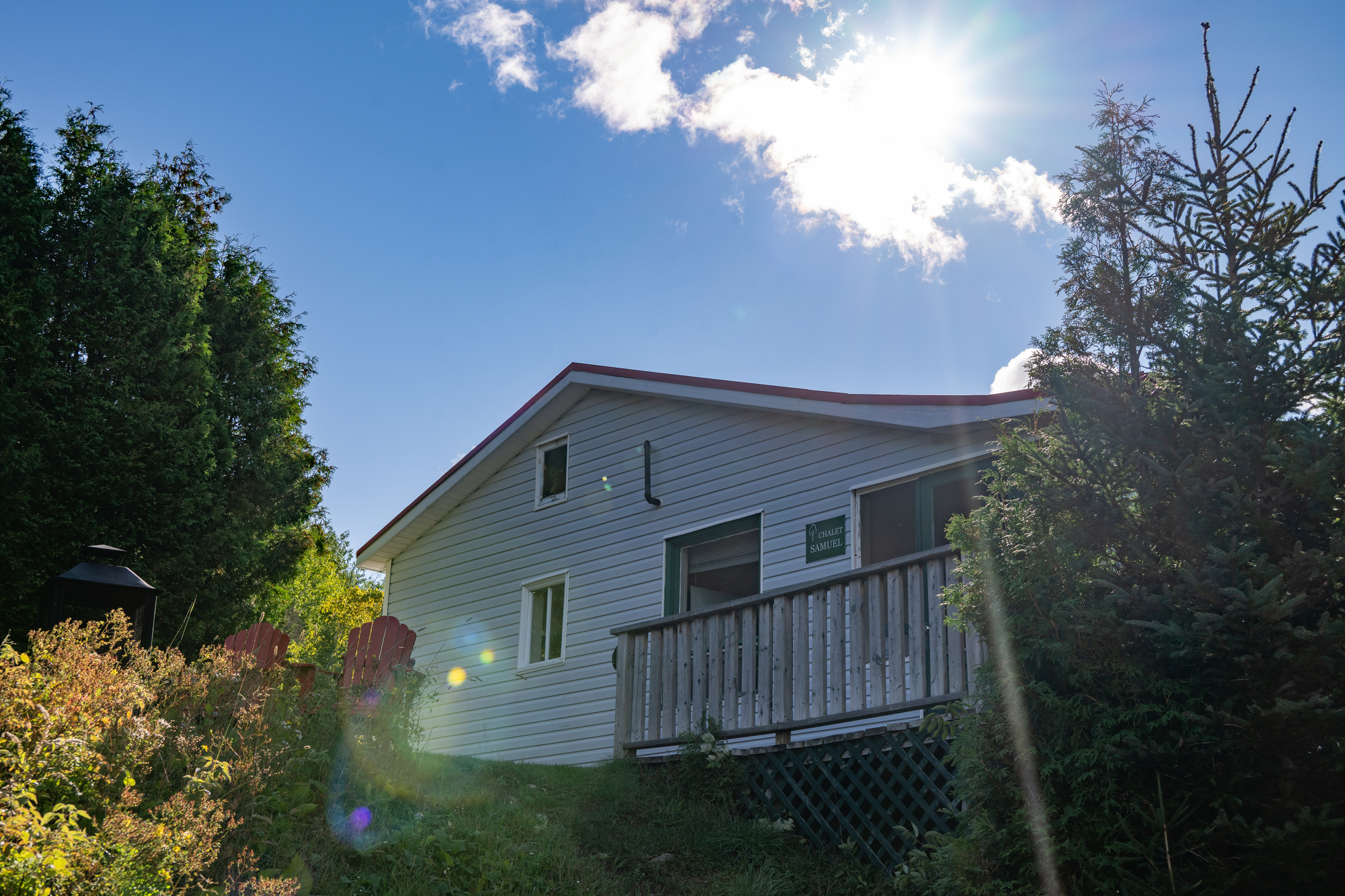 Chalet au lac François avec balcon, entouré de verdure et baigné de lumière, offrant un cadre idéal pour la pêche