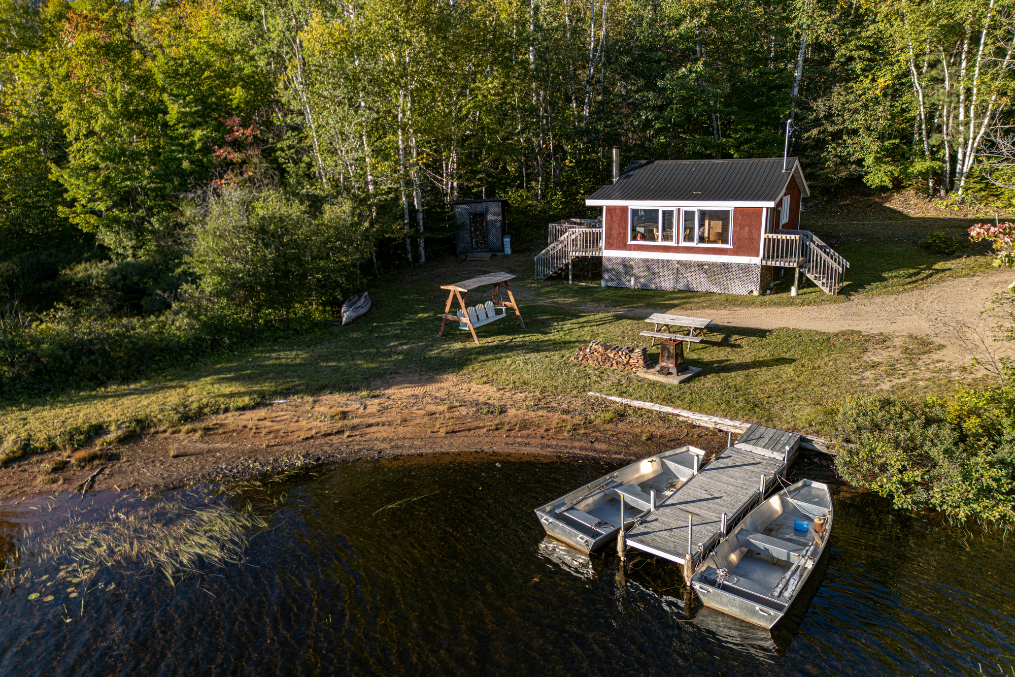 Chalet rustique au bord de l'eau avec embarcation et cadre naturel verdoyant dans Charlevoix